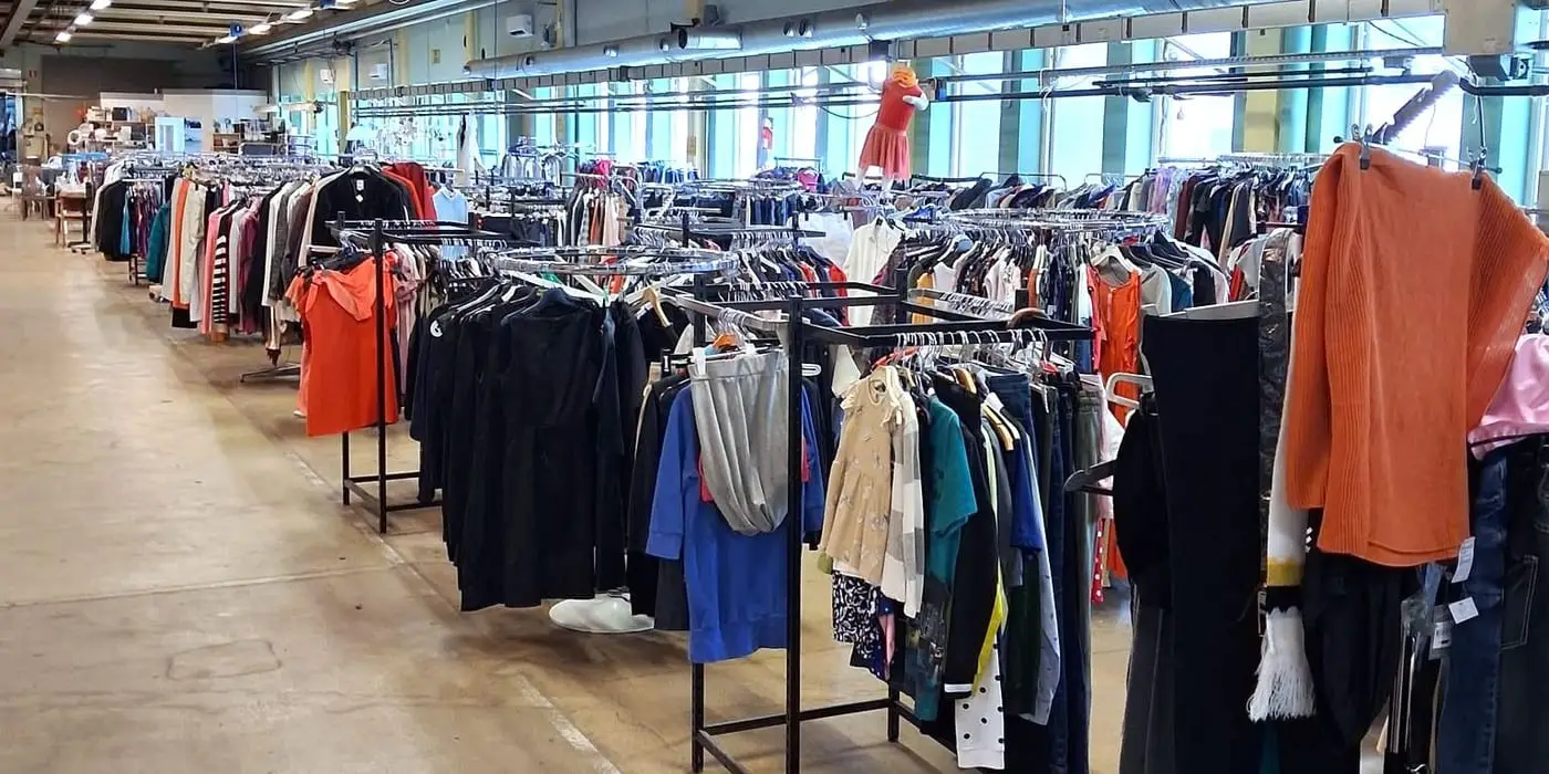 Långa rader med klädställningar under lysrör i Emmpatus Åkvarns second hand-butik i Torpsbruk